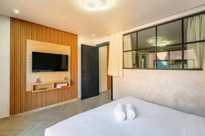 a bedroom with a bed with a tv on a wall at AYLAL Marrakech in Marrakech