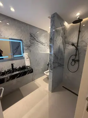 a bathroom with a shower and a sink and a mirror at Appartement moderne in Marrakech