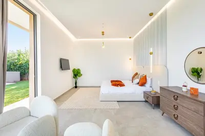 a white bedroom with a bed and a mirror at Villa Luxe Neuve , Piscine XXL , Sans vis-à-vis in Marrakech