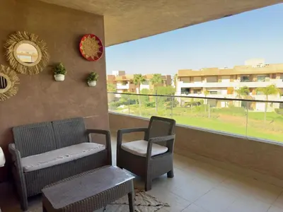 a balcony with two chairs and a window at Appartement with a view on the pool in Marrakech