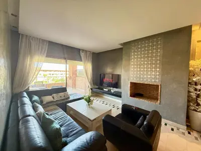 a living room with a leather couch and a fireplace at Appartement with a view on the pool in Marrakech