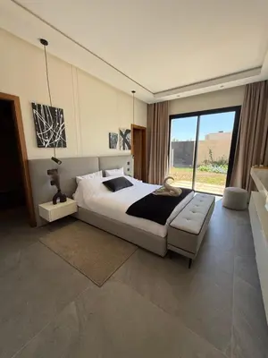 a bedroom with a large bed and a large window at Villa ALIYAH in Marrakech