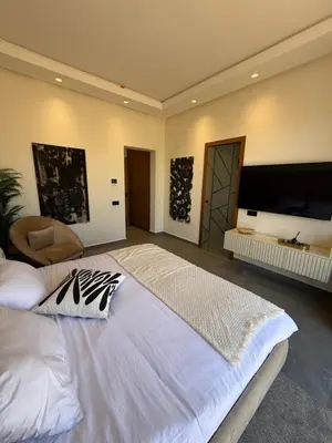 a large bedroom with a large bed and a flat screen tv at Villa ALIYAH in Marrakech