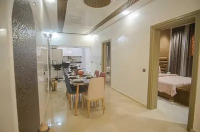 a dining room and living room with a table and chairs at Villa B with a private pool in Oulad Ikhia