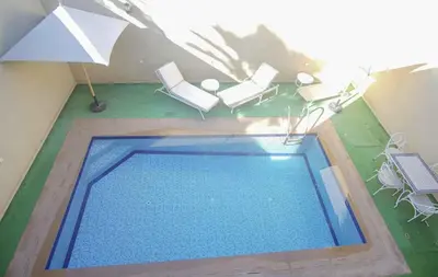 an overhead view of a swimming pool with chairs and an umbrella at Villa B with a private pool in Oulad Ikhia