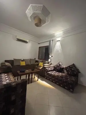 a living room with a couch and a table at Appartement 2 Chambres Confortable à Jnane Awrad Calme & Sécurité in Marrakech