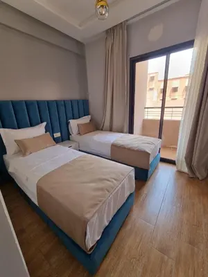 two beds in a hotel room with a window at Modern Fully equipped 2 rooms apartment in Marrakech