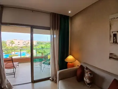 a hotel room with a view of a balcony at Appartement Prestigia Marrakech Maroc Golf Piscine in Marrakech