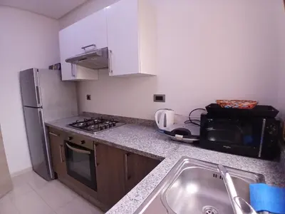 a kitchen with a sink and a microwave at Appartement Prestigia Marrakech Maroc Golf Piscine in Marrakech