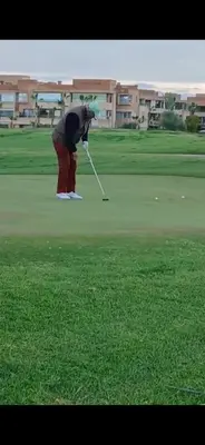a woman is playing golf on a golf course at Appartement Prestigia Marrakech Maroc Golf Piscine in Marrakech