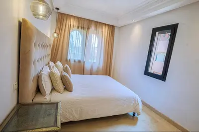 a bedroom with a white bed with a mirror at Generosa 22 in Marrakech