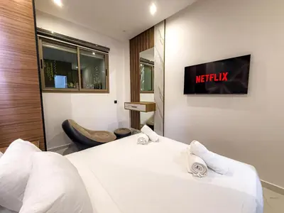 a hotel room with a bed and a tv on the wall at Séjour chic en ville Jacuzzi privé et Wi-Fi gratuit in Marrakech