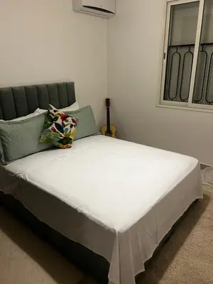a bed with white sheets and pillows in a room at Apartement Mabrouka in Marrakech