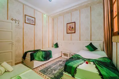 a small room with two beds in it at Riad Mazouz102 Médina in Marrakech
