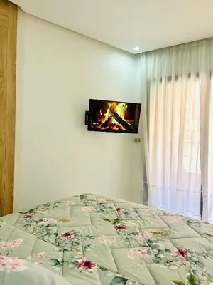 a bedroom with a bed and a tv on the wall at Appartement Gueliz in Marrakech