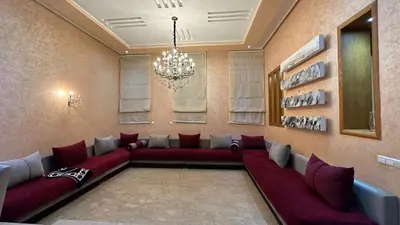 a living room with red couches and a chandelier at Oasis Luxury Villa Marrakesh in Marrakech