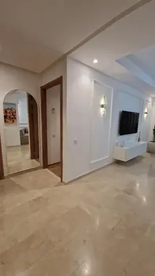 an empty living room with a television and a couch at Noria Isli Dar Noor in Marrakech