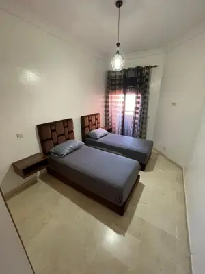 two beds sitting in a room with a window at Apparemment première village in Marrakech