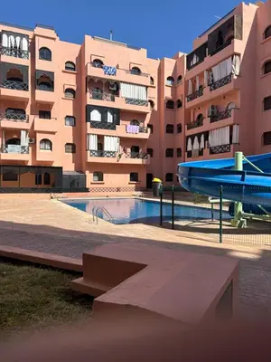 a swimming pool in front of a building at Apparemment première village in Marrakech