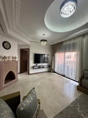a living room with a fireplace and a tv at Apparemment première village in Marrakech