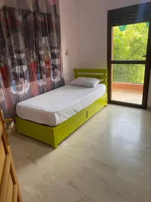 a yellow bed in a room with a window at Villa privée in Marrakech