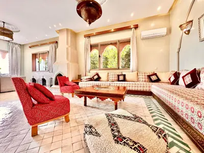 a living room with a couch and chairs and a table at Villa Luxueuse avec Piscine & Vue sur le Golf in Marrakech