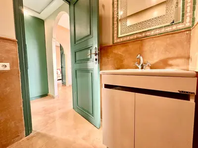 a bathroom with a sink and a green door at Villa Luxueuse avec Piscine & Vue sur le Golf in Marrakech