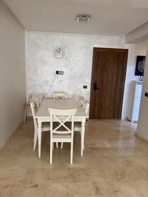 a white table and chairs in a room with a door at شقة رائعة في جليز خاصة بالعائلات in Marrakech