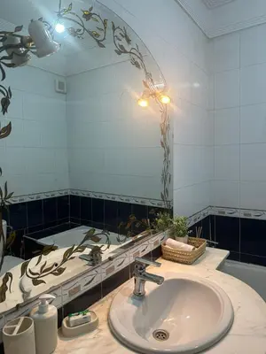 a bathroom with a sink and a large mirror at Dar Al Amina in Marrakech