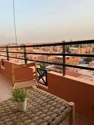 a balcony with a bench and a view of a city at Dar Al Amina in Marrakech