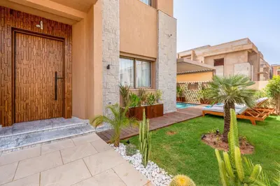 a front door of a house with a yard with palm trees at Villa Lina in Marrakech