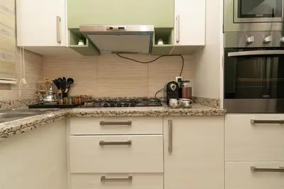 a kitchen with white cabinets and a stove at appartement luxe golf prestigia in Marrakech