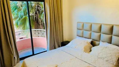 a bedroom with a bed and a large window at Spacieux appartement juste pour familles réservation juste pour les familles et les couples mariés in Marrakech