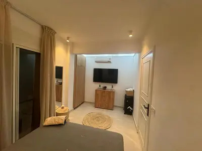 a room with a bed and a flat screen tv at Cosy Victor hugo in Marrakech