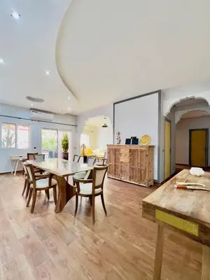 a large living room with a table and chairs at bel appartement in Marrakech