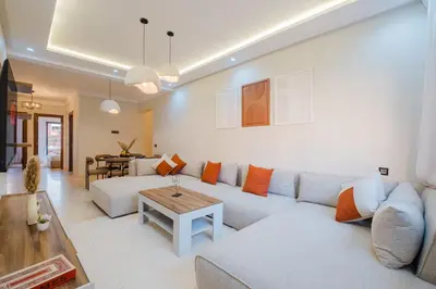 a living room with a white couch and a table at 3BR Luxury Stay - Hivernage- Pool View - Parking Near M Avenue & Rail in Marrakech