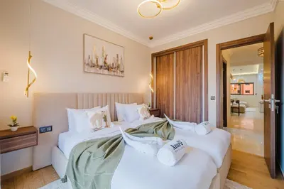 two beds in a hotel room with white pillows at 3BR Luxury Stay - Hivernage- Pool View - Parking Near M Avenue & Rail in Marrakech