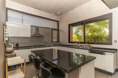 a kitchen with a black counter top and a window at jacuzzi, 2 pools, luxury villa in Marrakech