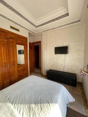 a bedroom with a bed and a television on the wall at Ma kech house in Marrakech