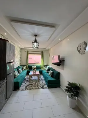 a living room with a green couch and a table at Global riad nawal in Marrakech