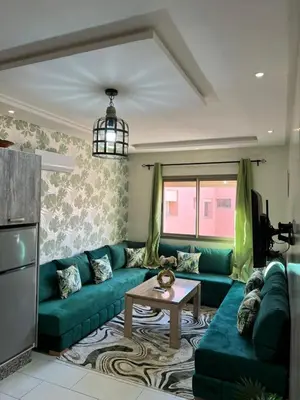 a living room with a green couch and a table at Global riad nawal in Marrakech