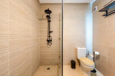 a shower stall with a toilet in a bathroom at Cocon Sable piscine et parking in Marrakech