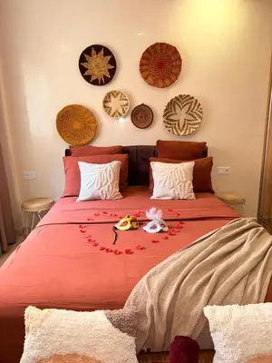 a bedroom with a large bed with a red blanket at appartement familial in Marrakech