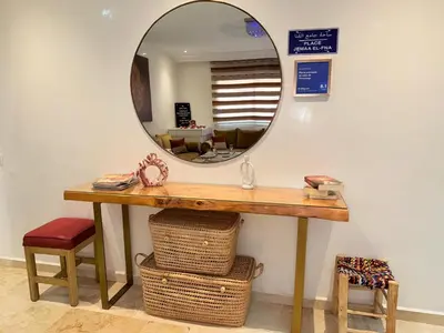 a mirror on a wall above a table with a mirror at appartement familial in Marrakech