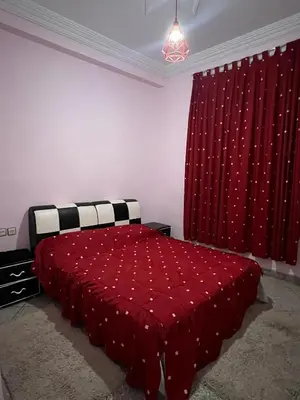 a bedroom with a red bed and a red curtain at Targa in Marrakech