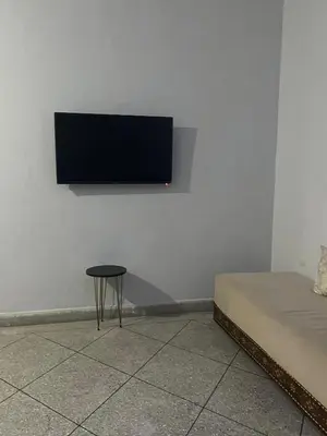 a flat screen tv hanging on a wall with a table at Targa in Marrakech