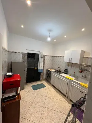 a kitchen with white cabinets and a washer and dryer at Targa in Marrakech