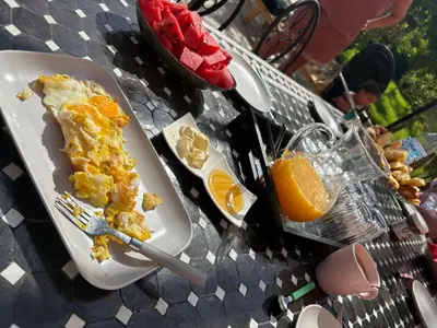 a plate of breakfast food on a table with orange juice at L ÉdenS in Marrakech