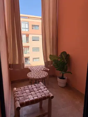 a room with a window with a bench and a plant at Magnifique appart Moderne 2ch 4pax Tout Confort in Marrakech
