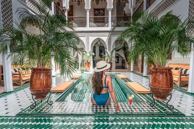 a woman in a hat sitting in a pool at a hotel at Marrakech Riads, NL Collection in Marrakech